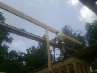 Carpenter setting a ridge beam over a new addition frame — Ice Dam Removal by Roofing Brothers in Banning