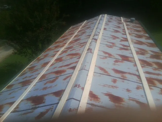 Rusted metal roof panels with new wood purlins before replacement — Storm Damage Roof Repair in Banning by Roofing Brothers